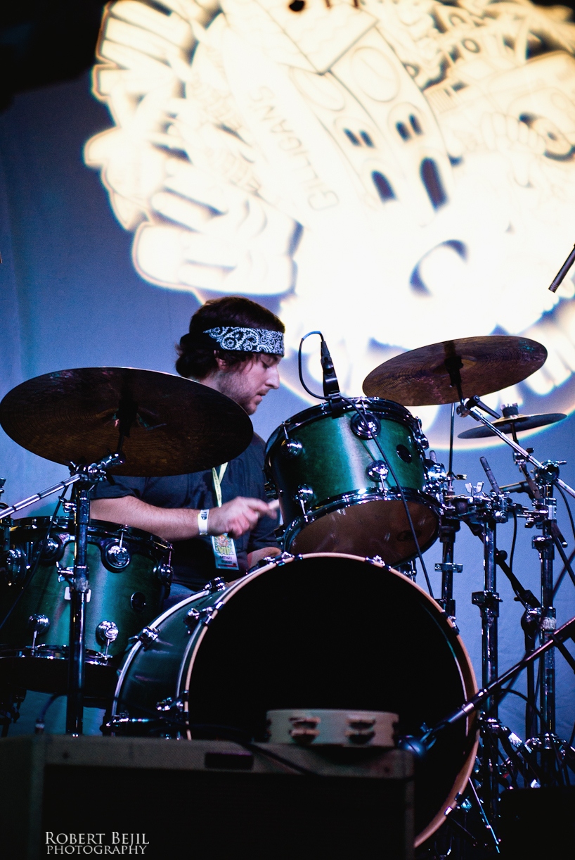a person playing drums on stage in front of a projector screen