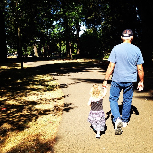 a man walking down a pathway next to a little girl