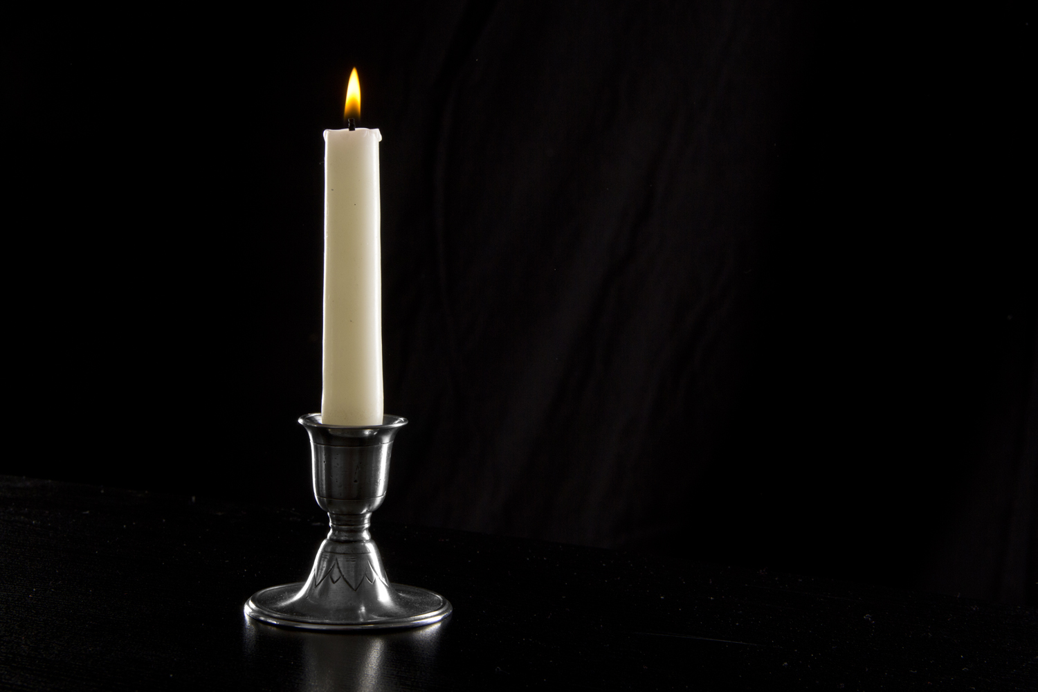a candle sitting on top of a black table