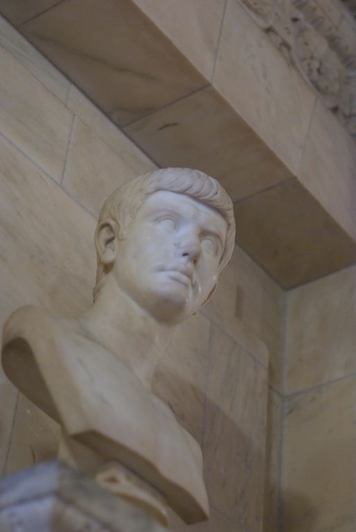 a statue sitting next to a stone wall