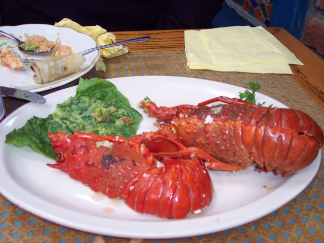 a lobster with spinach, green vegetables and sauces