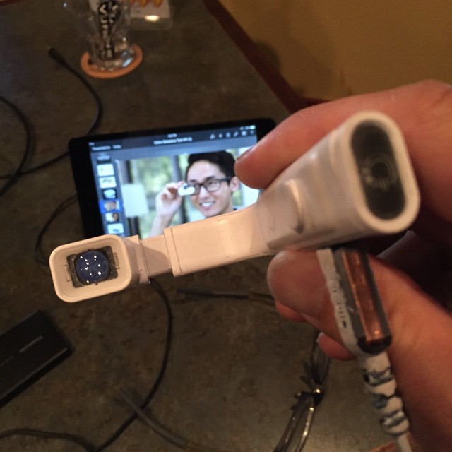 someone using a device that displays a picture of a person with glasses