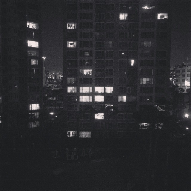 some tall buildings are seen at night in the dark