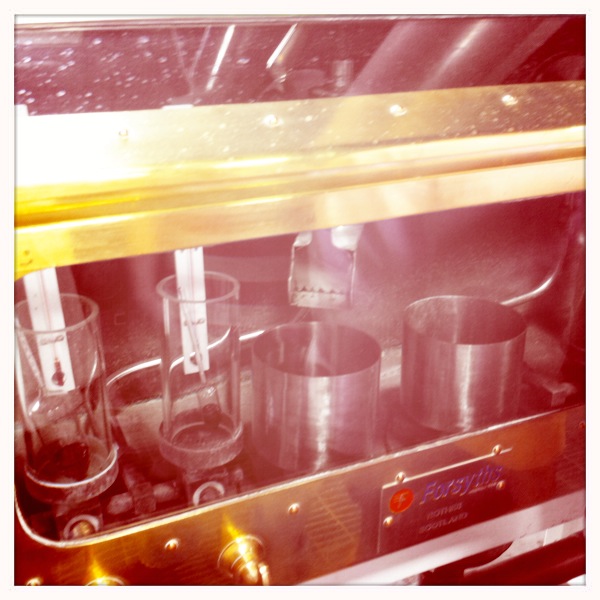 an empty stainless steel oven with cups and bowls on the side