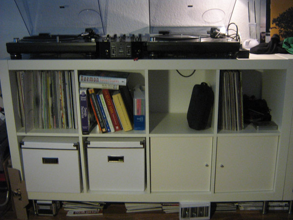 a white entertainment center with many cd's