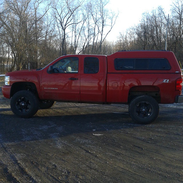 a red truck parked in the snow in a parking lot