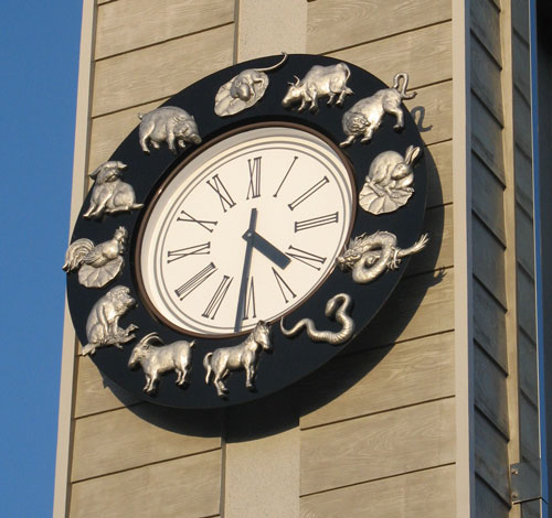 a clock is decorated with silver elephants and elephants