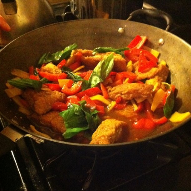 chicken with vegetables cooking on top of an oven