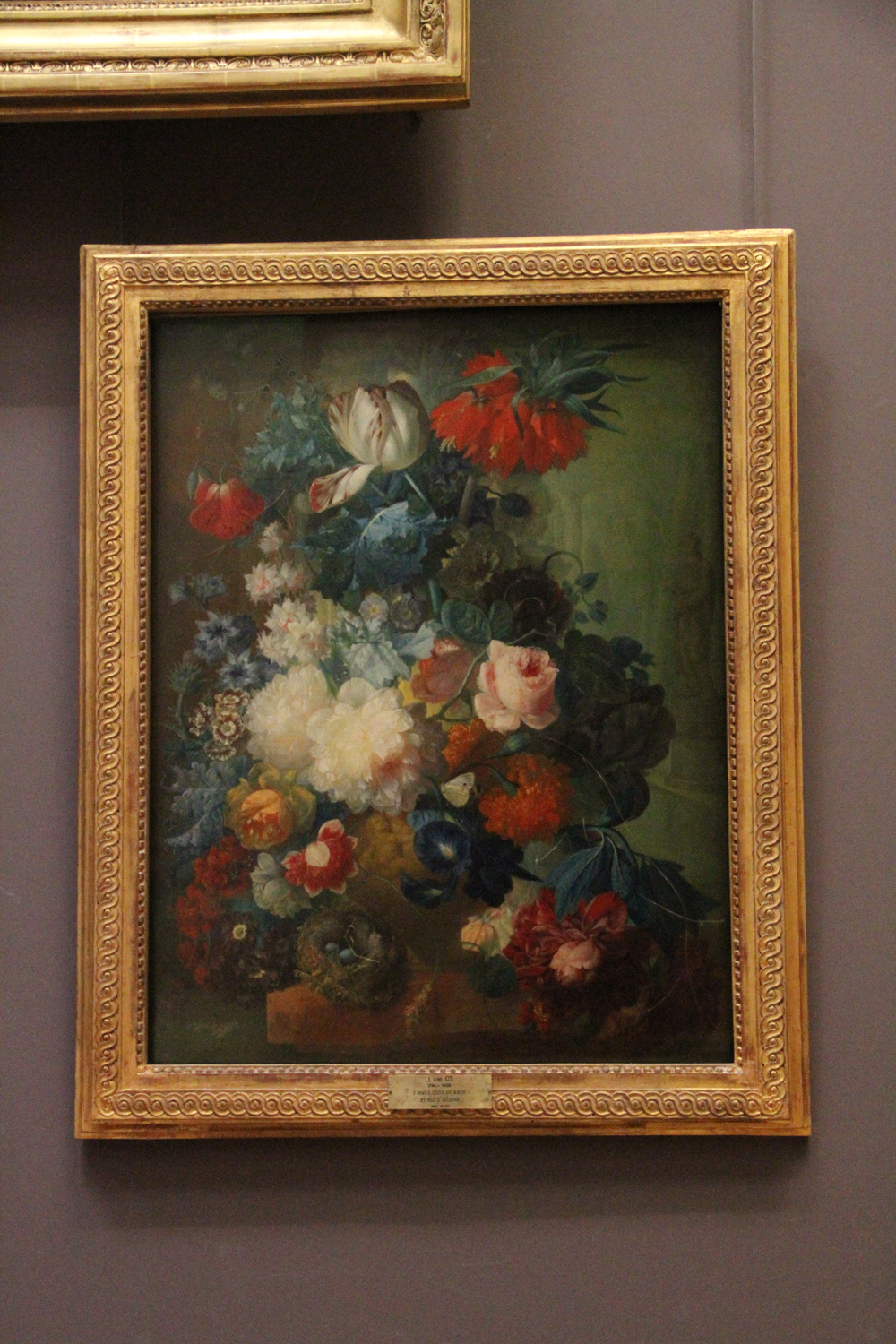 painting of flowers displayed on wall with antique gold frames