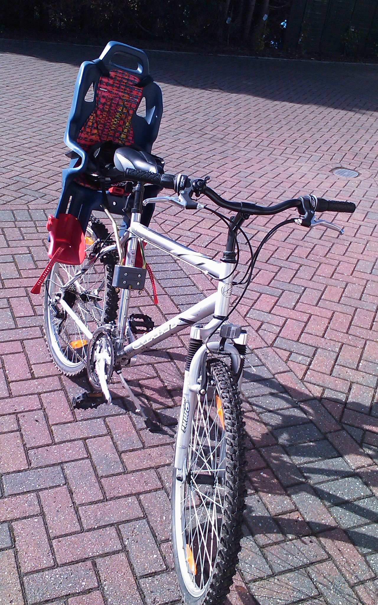 the bicycle is in an unpaved position on a red brick street