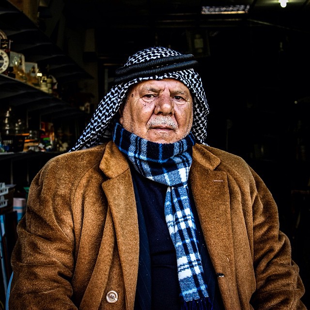an older man in his store is standing