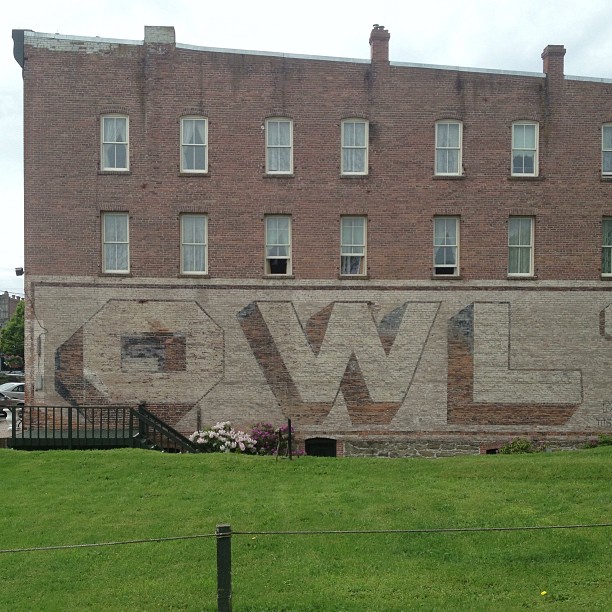 a tall brick building with the word wow painted on it