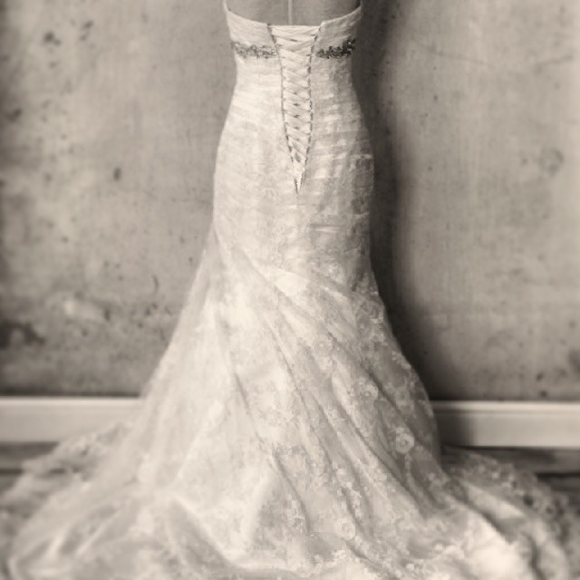 a woman in a wedding dress is standing next to a wall