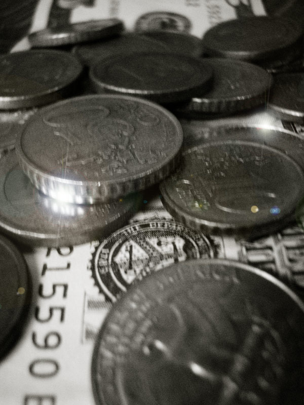 a bunch of silver coins sitting on top of a stack of money