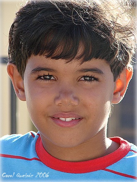 a boy smiling, looking at the camera