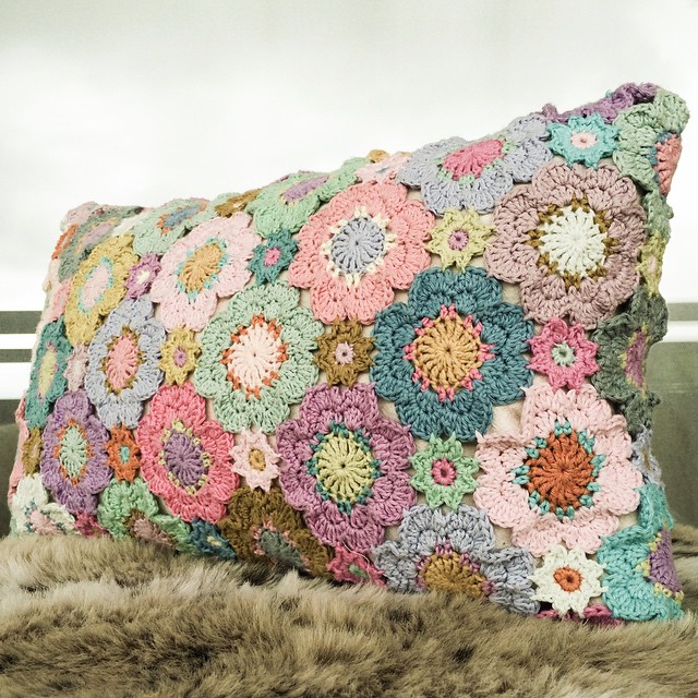 colorful crochet flowers sit on a multi - colored cushion