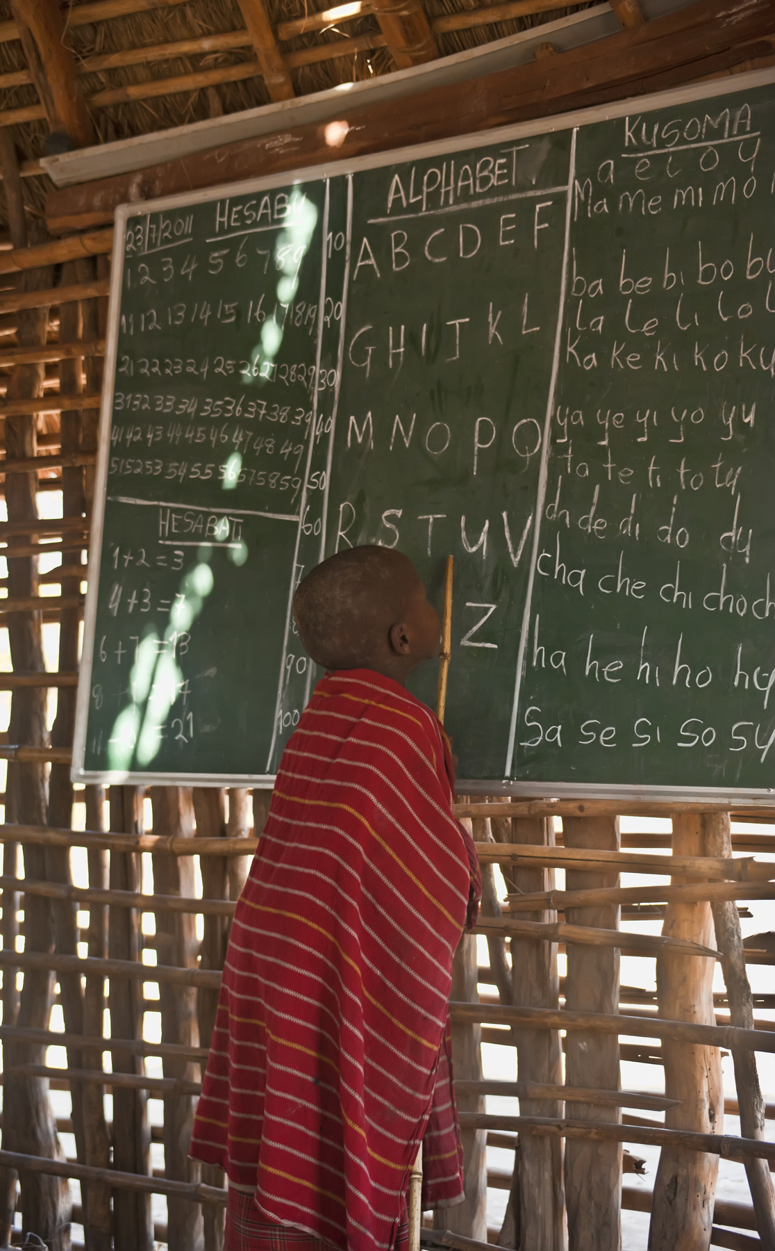 a person writing on a blackboard at the back of a wooden hut