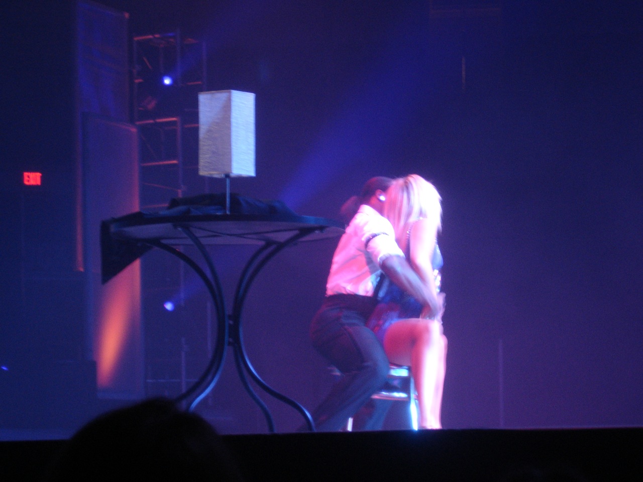 a person kneeling down next to a small table on a stage