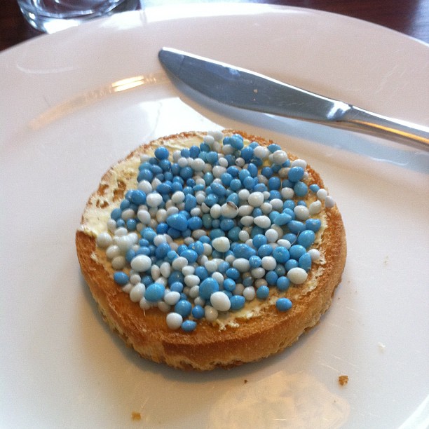 a cake with blue, white and blue sprinkles is shown