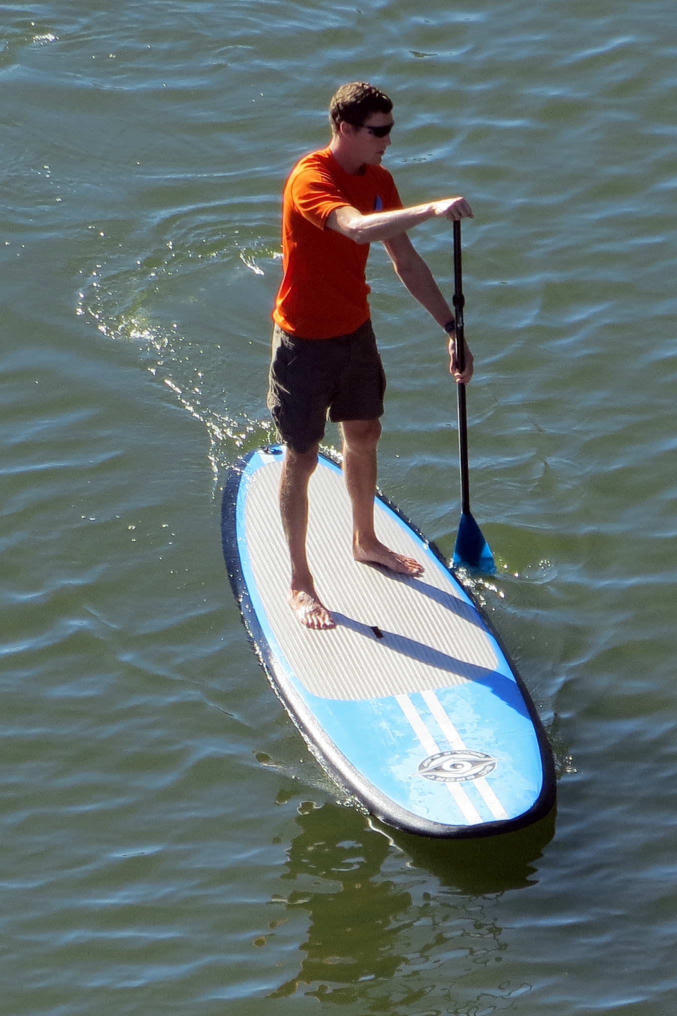 the person on the surfboard is holding a oar