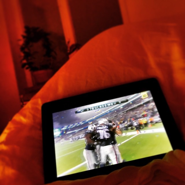 a football game on an ipad is playing in bed