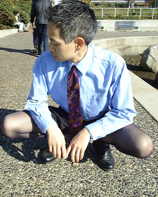 a man sitting on the ground tying his shoe