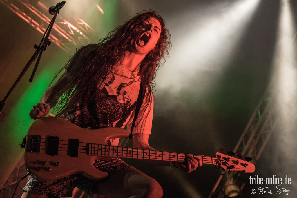 a woman is holding up a guitar on stage