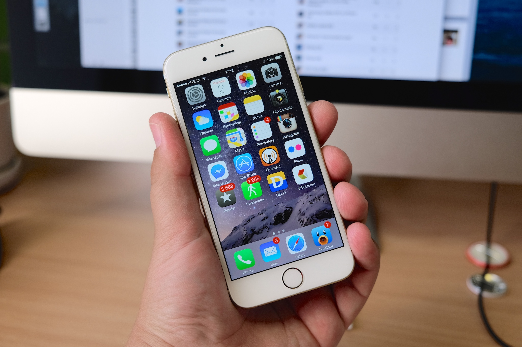 someone holding an iphone up on a desk