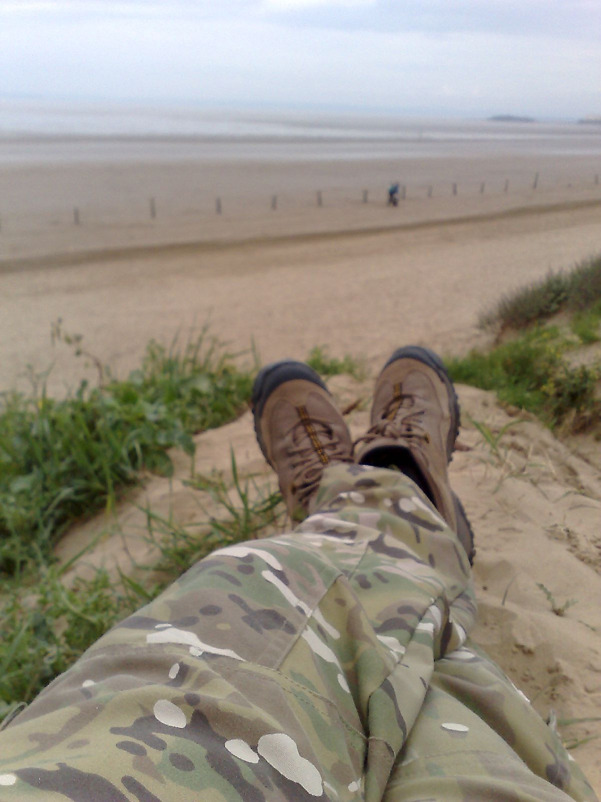 the legs and feet of a person lying down on a beach