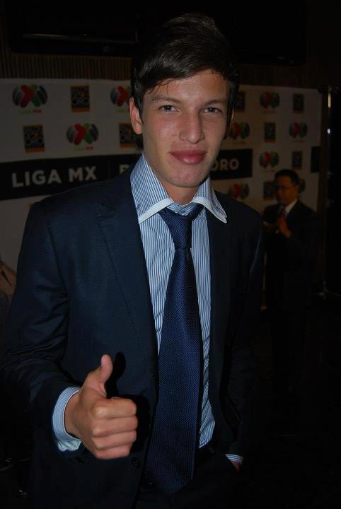 a young man with blue and white stripe tie giving a thumbs up