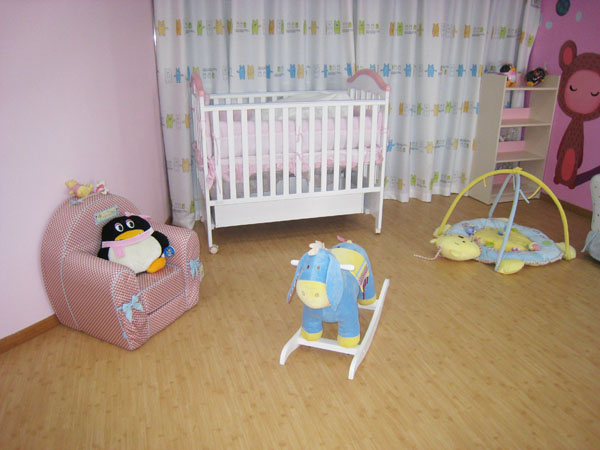 two toy elephants on wooden floors in a pink nursery