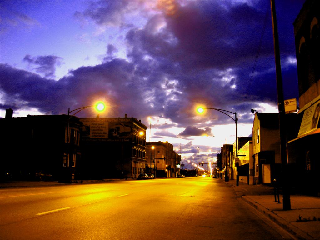 an empty street that is empty and has the evening lighting shining
