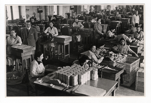 workers in a factory doing garments in crates