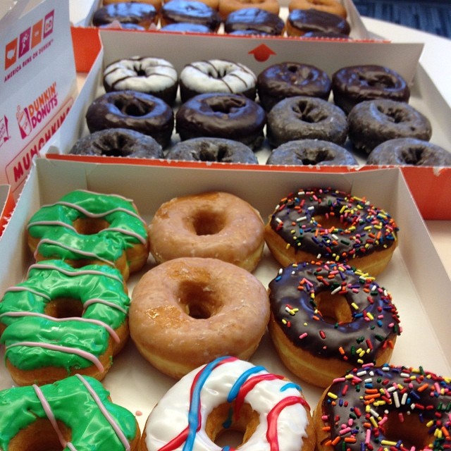 two boxes of donuts with frosting and decorated with sprinkles