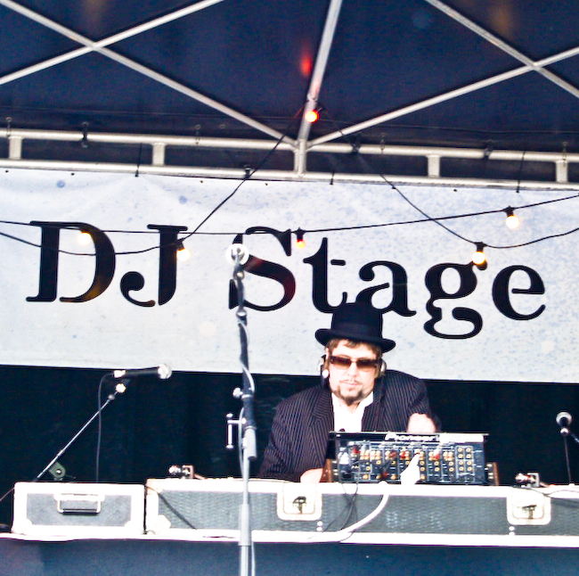 a dj with sunglasses is on the stage playing his electronic