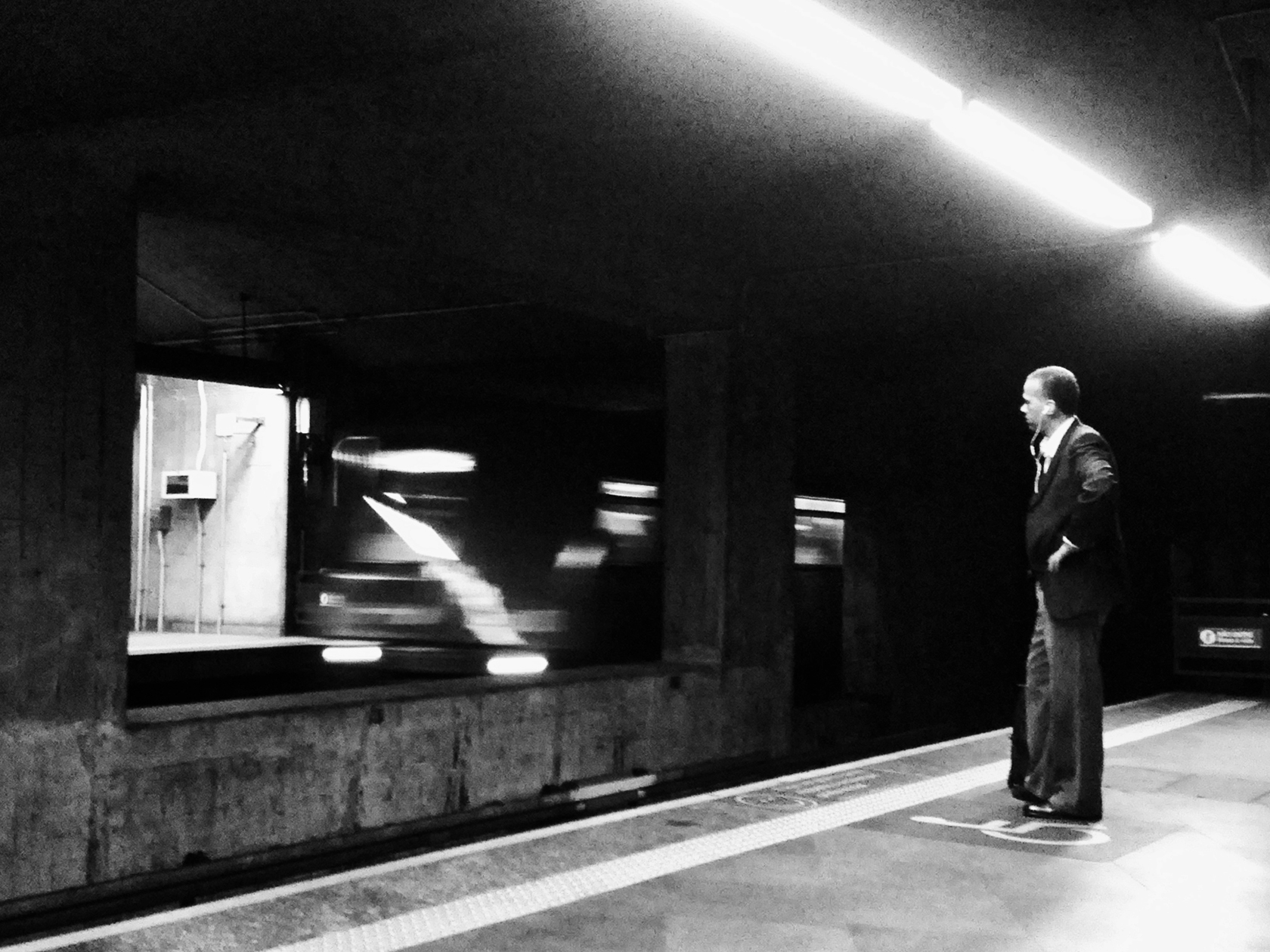 a man standing in a subway station, in front of the subway entrance