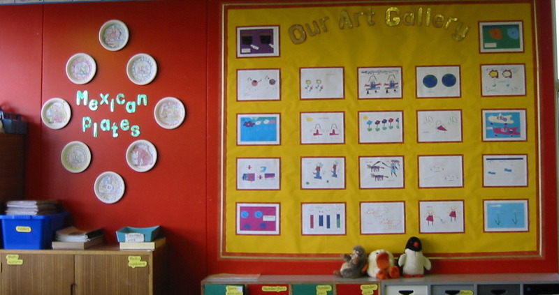 classroom with a bulletin board decorated with images and paper