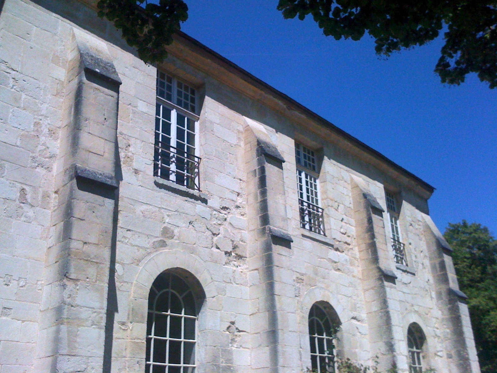the windows of a stone building with a fence