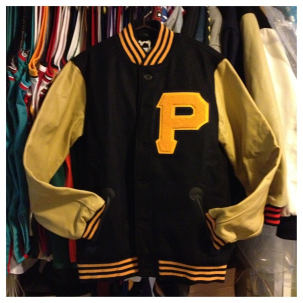 a baseball jacket with yellow lettering in a room