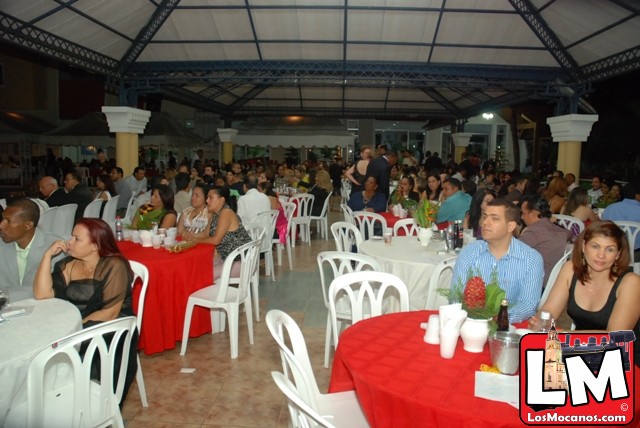 a large room filled with people sitting and eating food