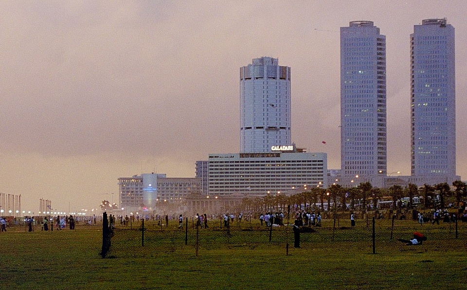a large field with buildings in the background
