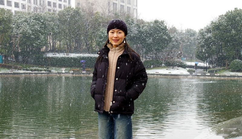 woman standing in front of the water wearing winter clothing