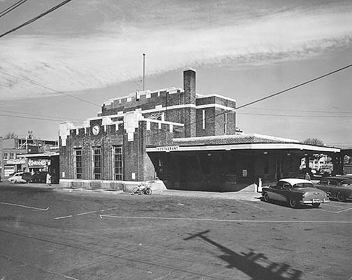 an old picture of the building with cars in it