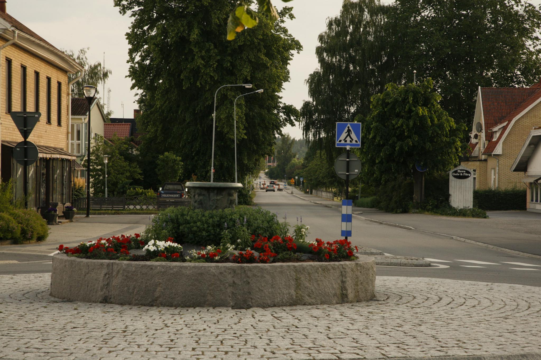 a sign and flowers in the middle of a street