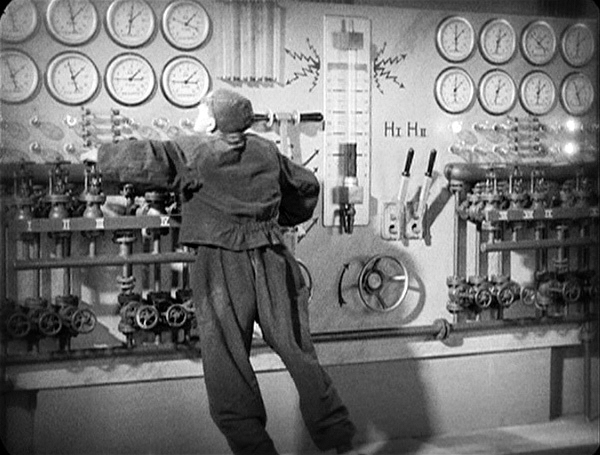 a man operating a large machine with many clocks on the wall