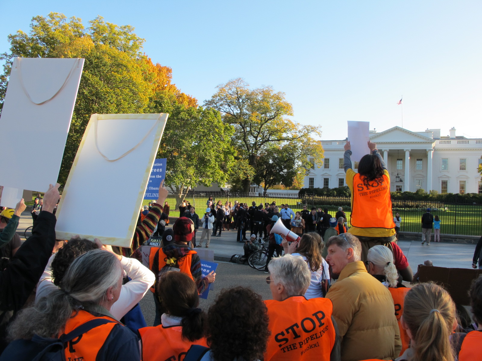 people with orange jackets and some holding signs