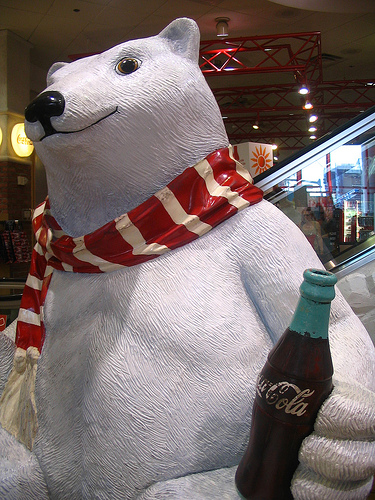 the sculpture of a polar bear holding a bottle of soda