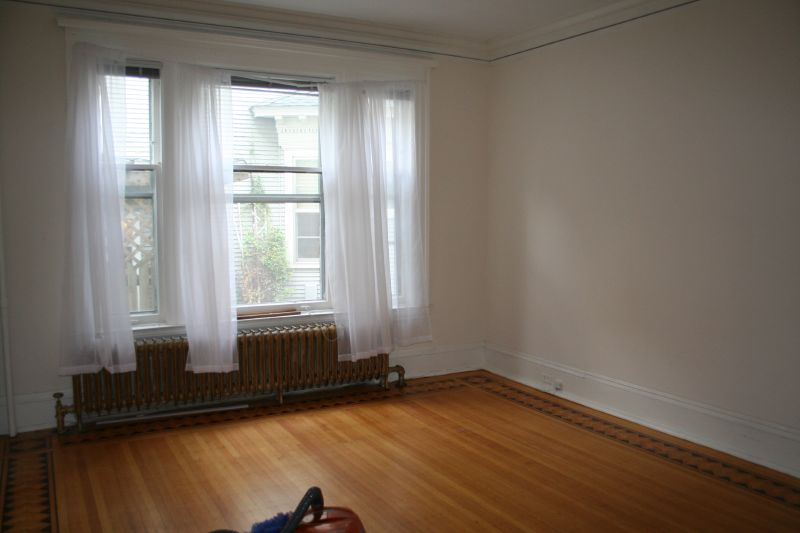 a hard wood floor in a room with white walls and a radiator