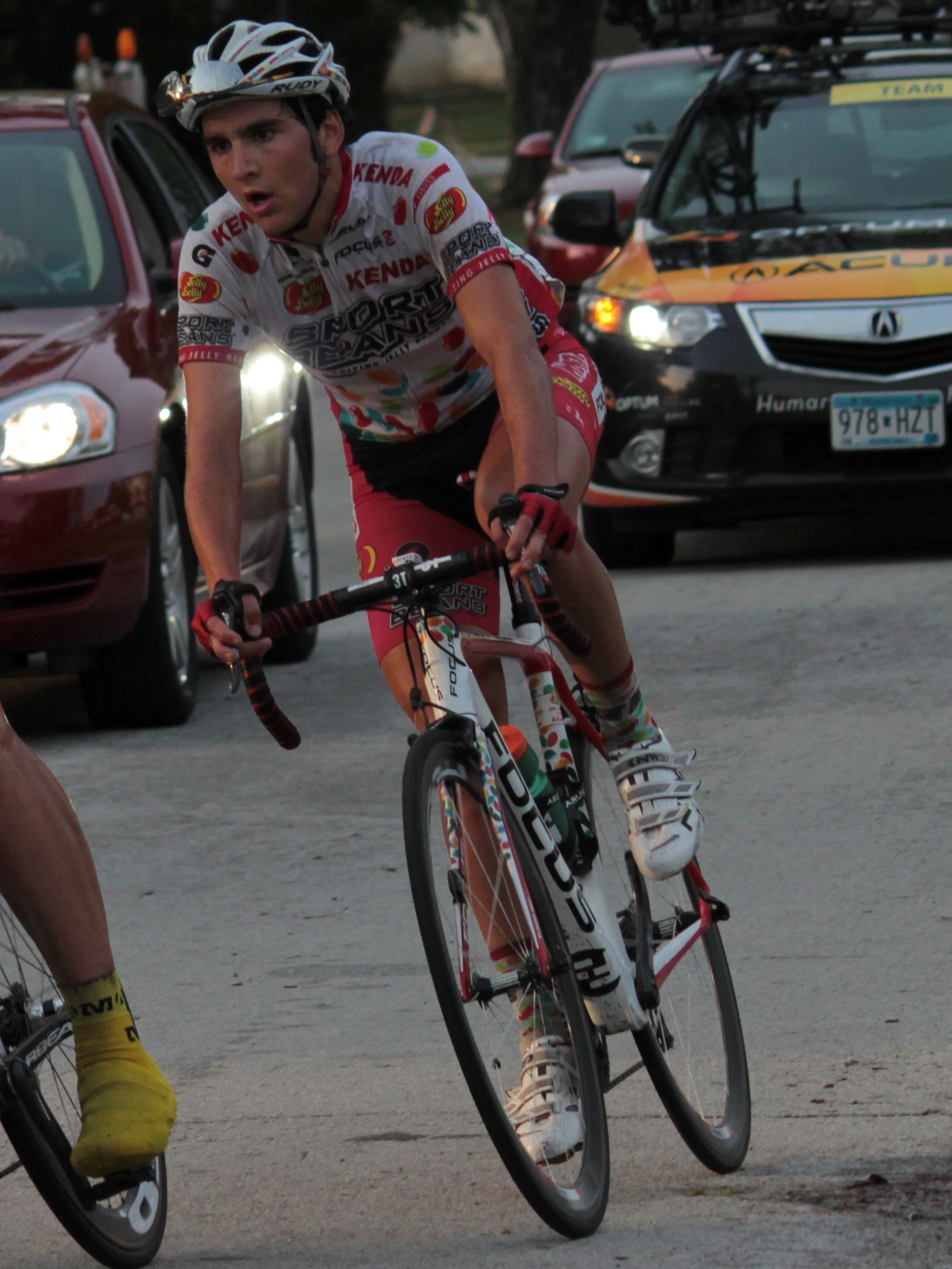 man on bicycle in traffic with cars near by