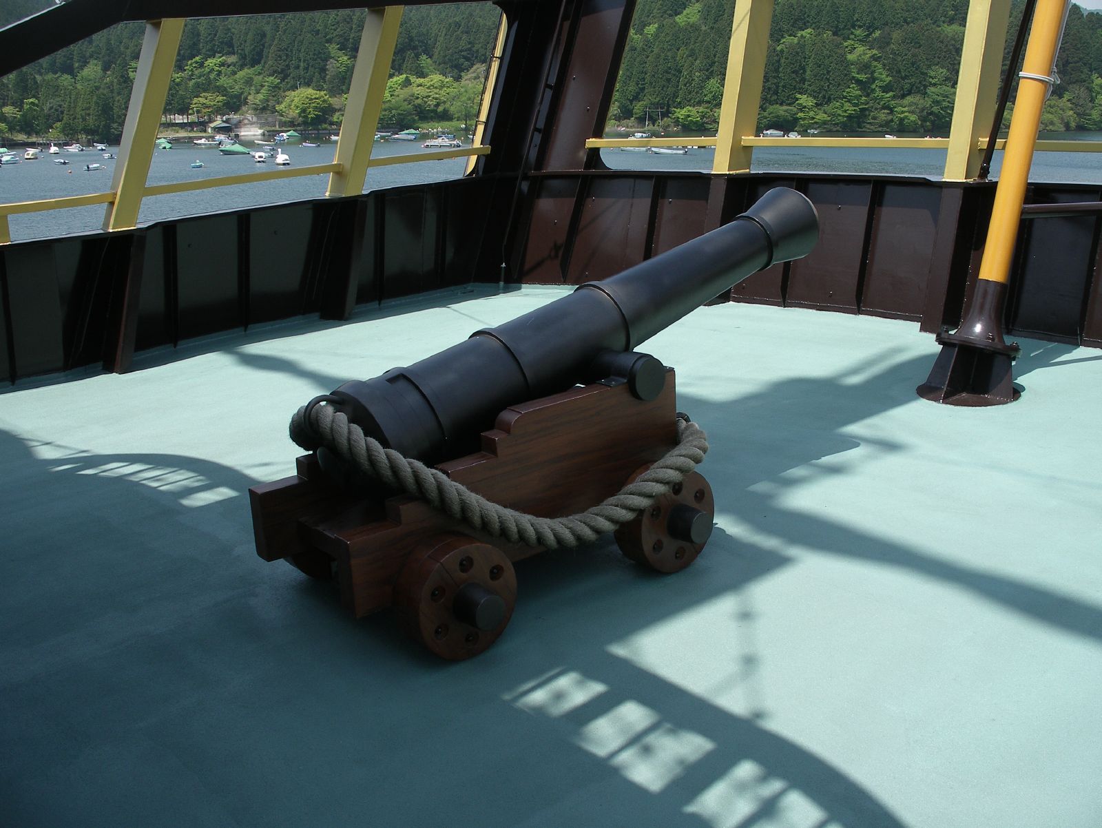 large telescope laying on top of wooden cart with rope